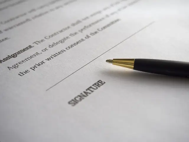 A black pen positioned above a signature line on a legal document with printed text visible